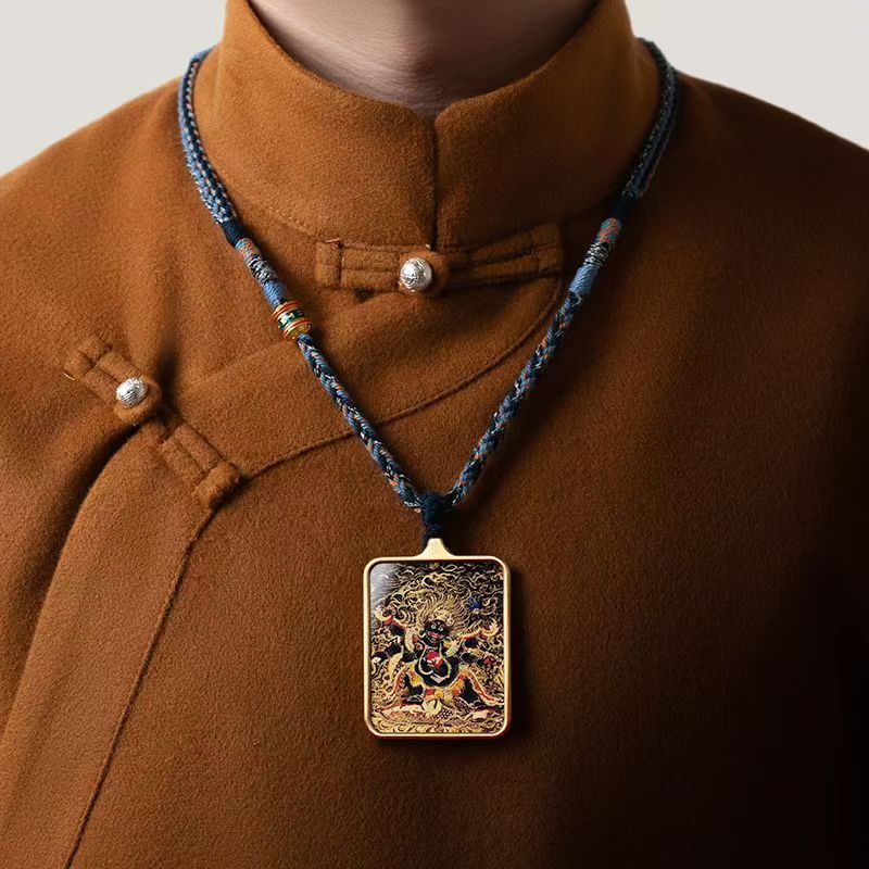 A person in a brown traditional outfit wears Joyce’s Tibetjewelry’s Thangka Pendant—a hand-painted Palden Lhamo amulet necklace for protection and prosperity, reflecting Tibetan spiritual artistry.